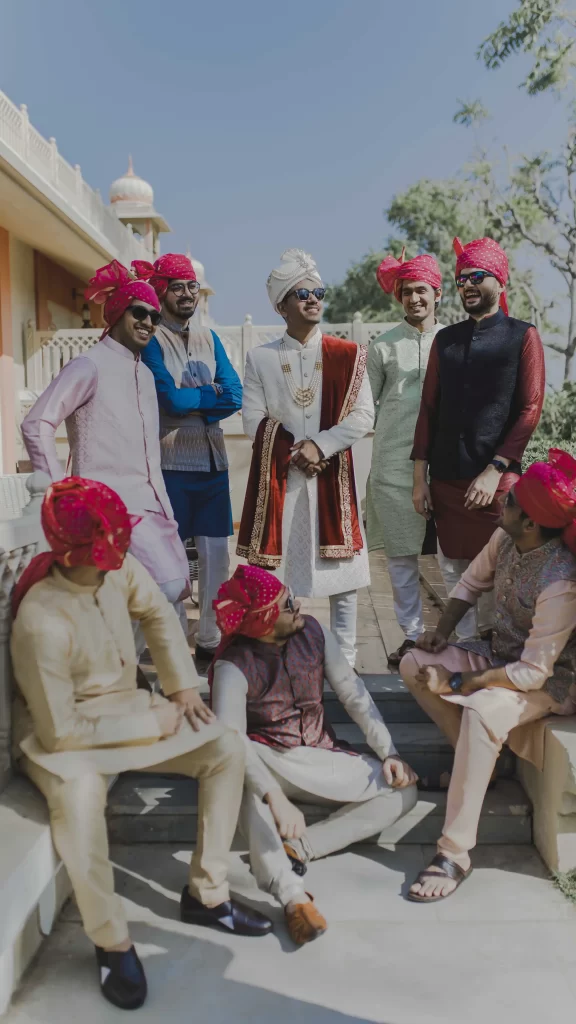 The groom stands proudly alongside his friends, exuding camaraderie and joy as they capture a memorable moment together before the wedding festivities.