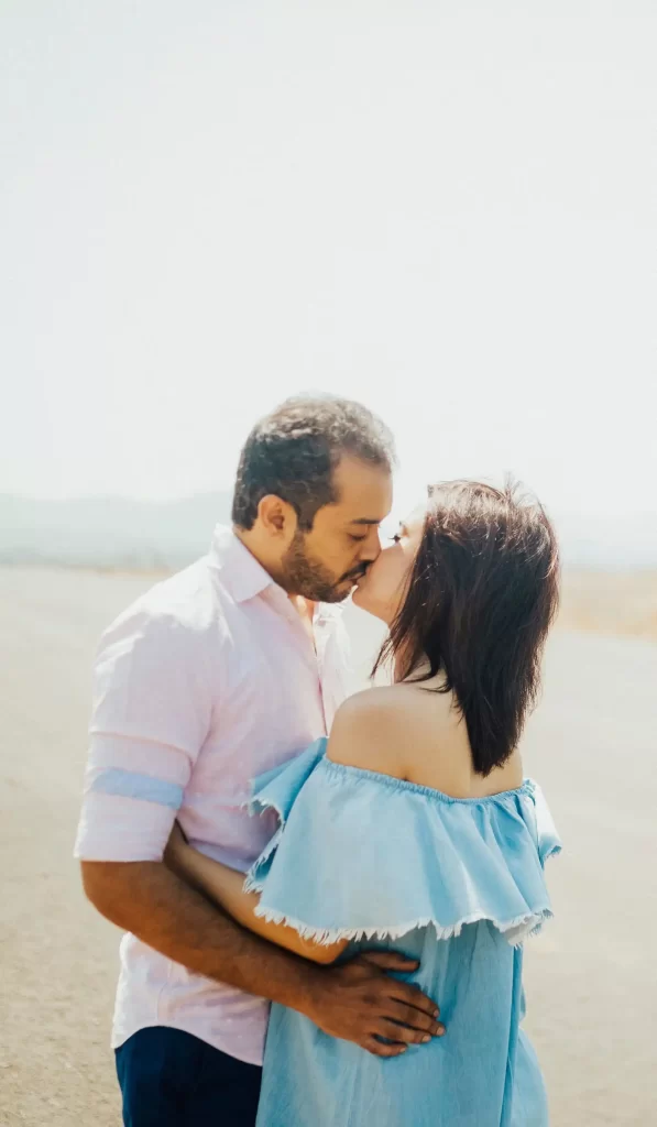 A loving couple embraces in a kiss during their pre-wedding photoshoot, expressing their joy and excitement for their upcoming marriage.