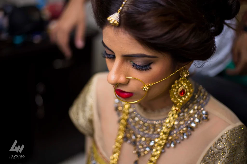 A photograph showcasing the bride getting ready for her wedding, surrounded by bridal attire, makeup, and accessories, as she prepares for the special day