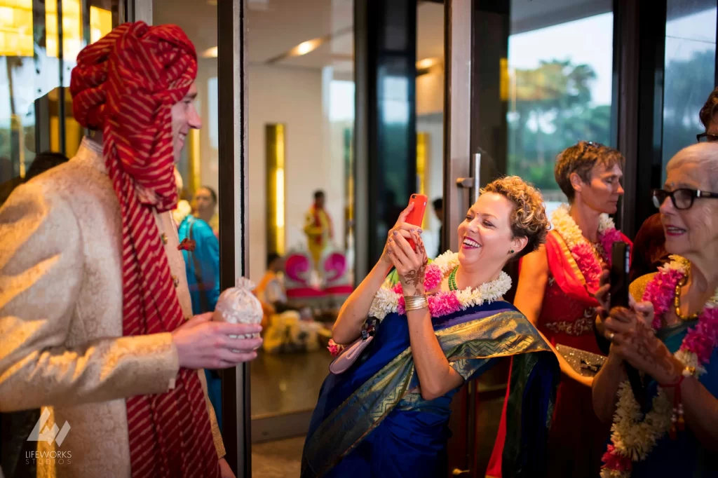 An image of a guest capturing a candid moment of the groom, reflecting the joyful and celebratory atmosphere of the wedding event.