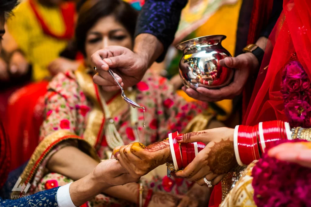 An image depicting the bride and groom performing puja (ritual worship) during their wedding day, symbolizing spiritual devotion and the sanctity of their union in Hindu tradition.