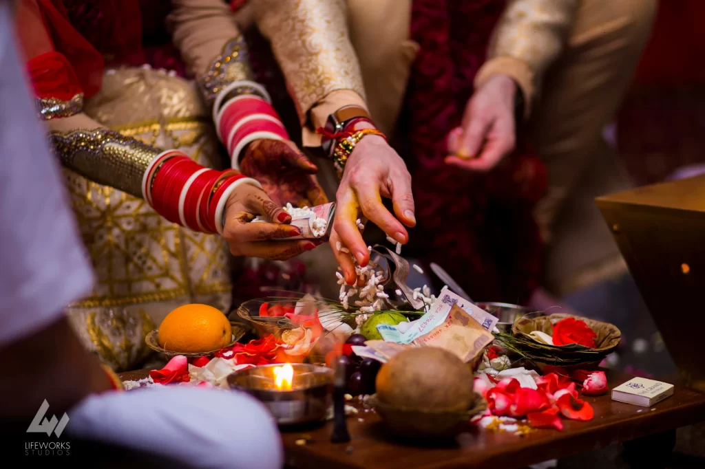 An image depicting the bride and groom performing puja (ritual worship) during their wedding day, symbolizing spiritual devotion and the sanctity of their union in Hindu tradition.