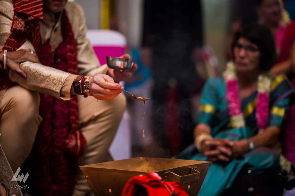 An image depicting the bride and groom performing puja (ritual worship) during their wedding day, symbolizing spiritual devotion and the sanctity of their union in Hindu tradition.