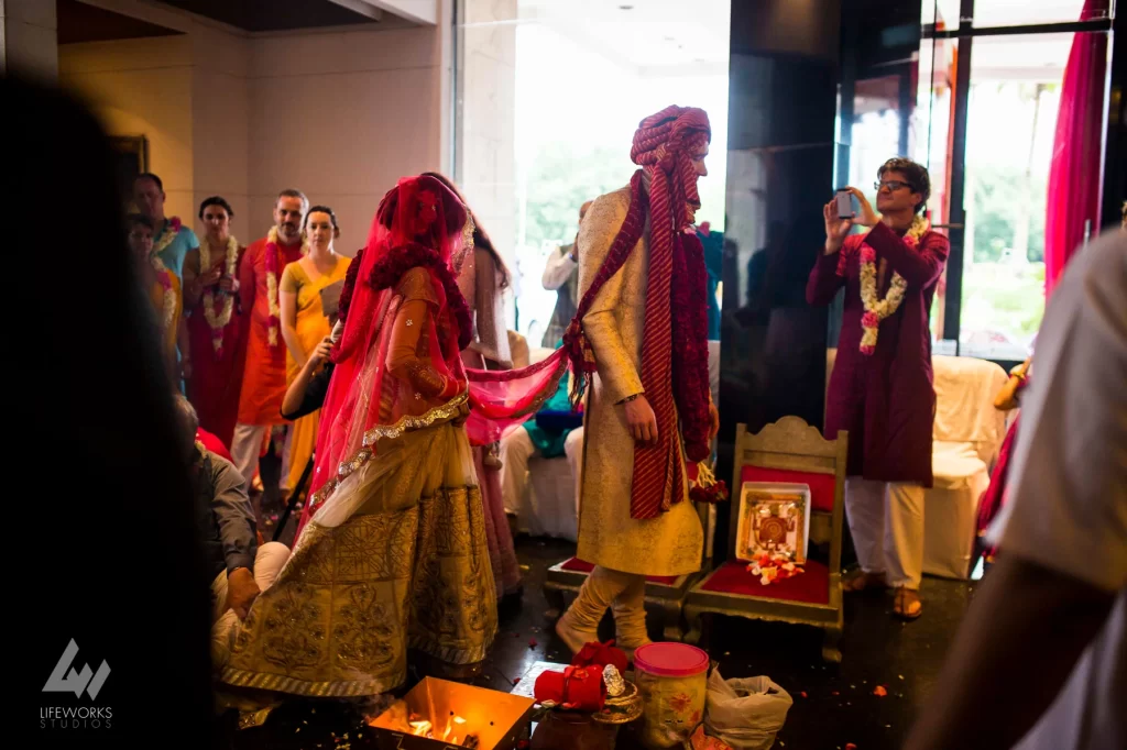 An image portraying the bride and groom taking the pheras (circling the sacred fire) during the wedding ceremony, symbolizing the sacred vows and commitment as they embark on their marital journey.