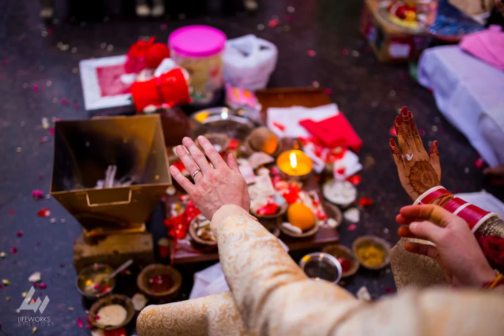 An image capturing the bride and groom participating in traditional wedding ceremonies, surrounded by sacred rituals, symbolizing the sacred union and commitment in the auspicious celebration.