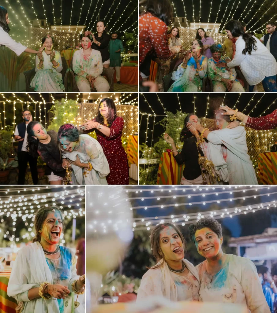 Two brides, surrounded by joyful guests, celebrating Holi with vibrant colors, creating a lively and festive atmosphere at their wedding.