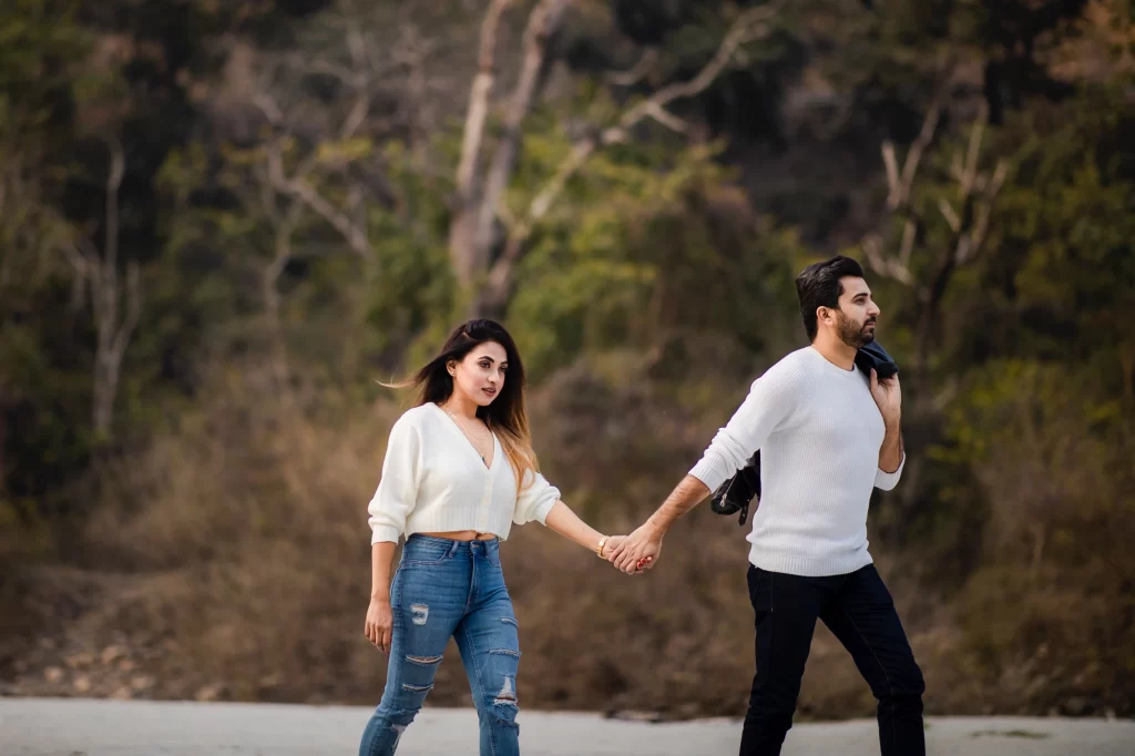 A photograph captures a couple walking hand in hand. Their intertwined hands and synchronized stride reflect a deep connection and unity, symbolizing love and companionship.