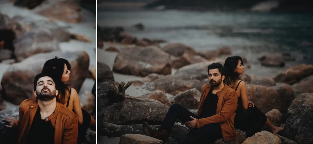 A couple sitting close together on a rock near a peaceful river during a pre-wedding photo shoot