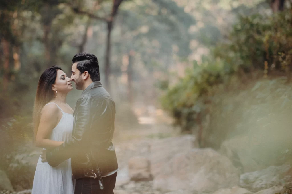 In a pre-wedding photoshoot, a couple strike a romantic pose exemplifying love and togetherness amidst a captivating backdrop.