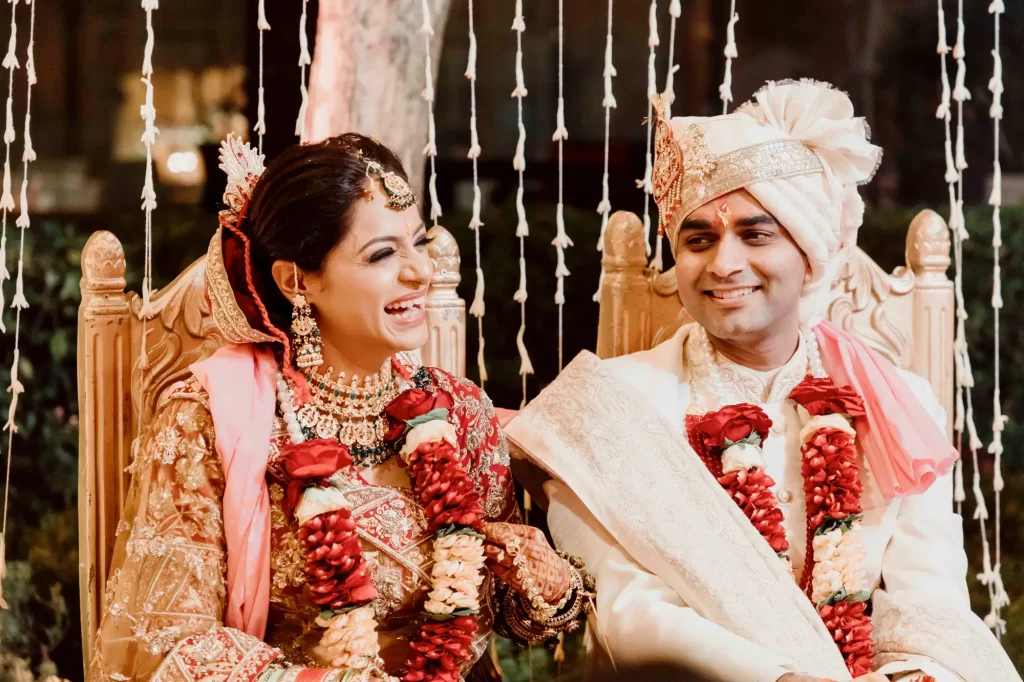 A happy couple embracing and smiling, radiating joy and love in a candid moment captured amidst their wedding celebrations.