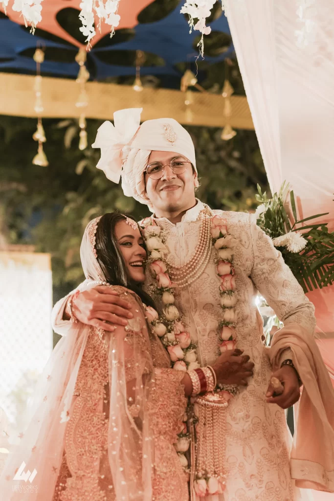 Bride and groom embrace each other affectionately after the Varmala ceremony, marking the joyful union and love between the newlyweds in a traditional wedding celebration.