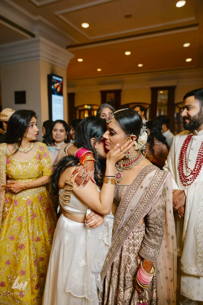 a bride and her sister exchange a tearful embrace during the emotional bidai ceremony, expressing deep emotions as they part ways.