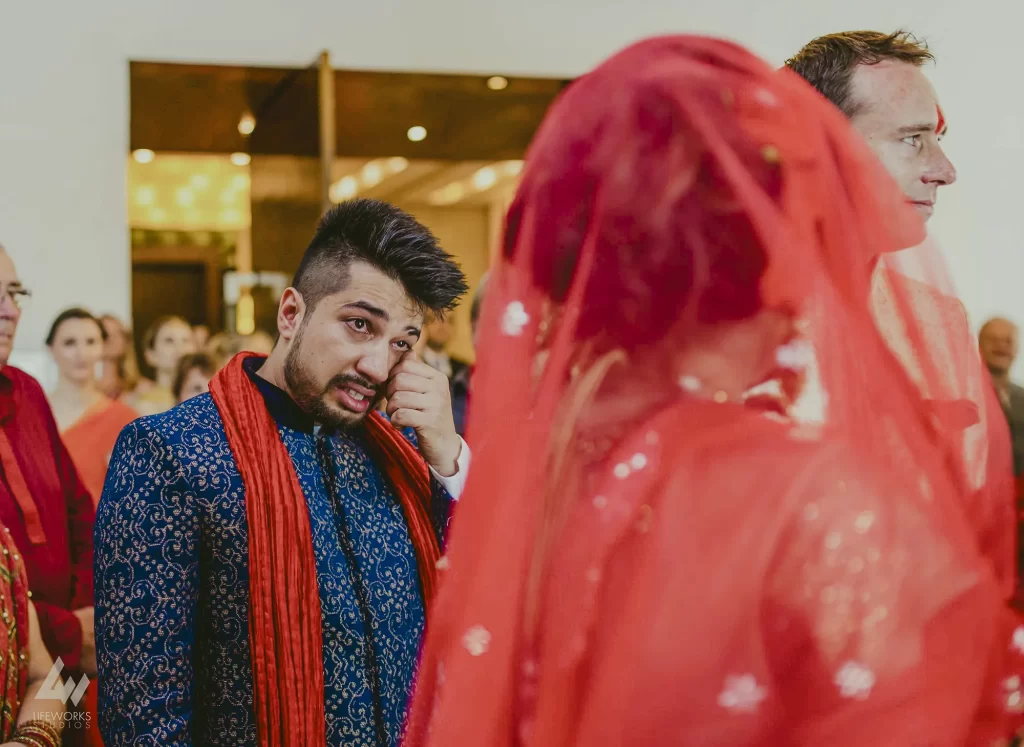 A brother in traditional attire shedding tears during a 'bidaai' ceremony, reflecting the emotional farewell in Indian wedding tradition.