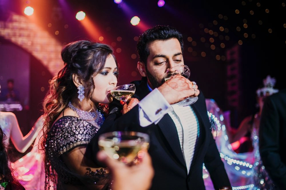 The bride and groom enjoy drinks at their cocktail party, showcasing relaxation, camaraderie, and celebration amid their wedding festivities