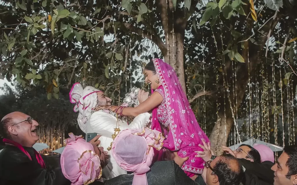 Indian varmala ceremony exchanging flower garlands symbolizing love and union between bride and groom, captured in a vibrant and cultural setting.