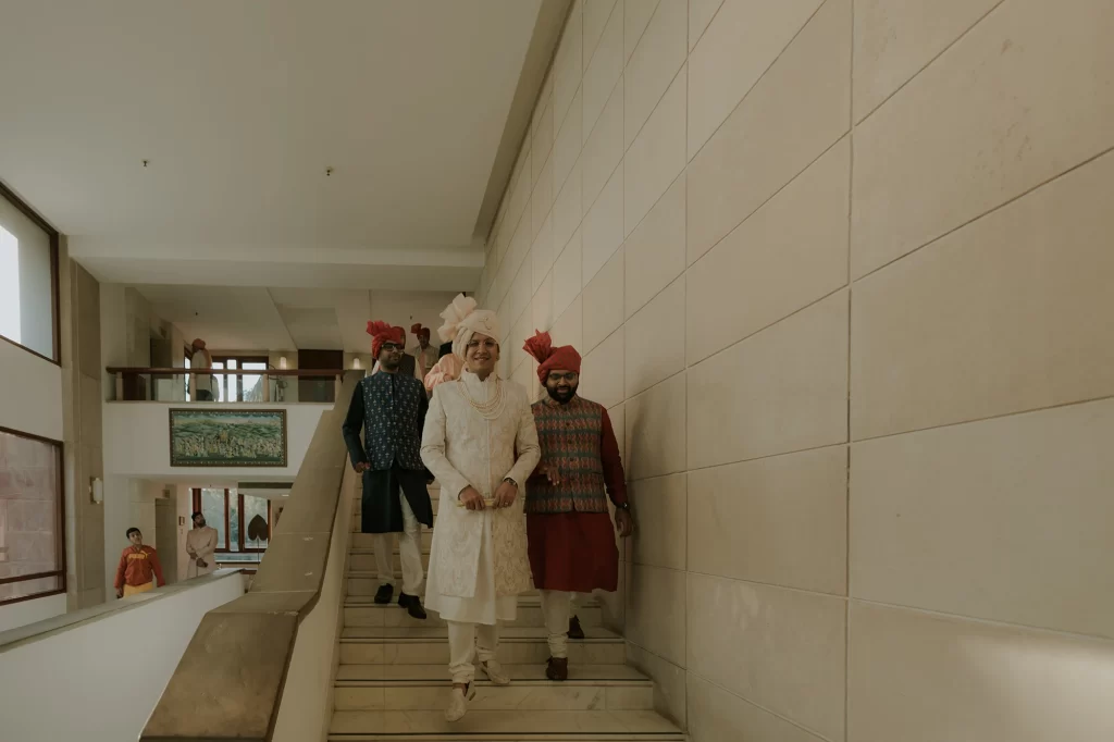  A groom elegantly walks towards the wedding venue, exuding confidence and anticipation as he approaches the auspicious celebration.  