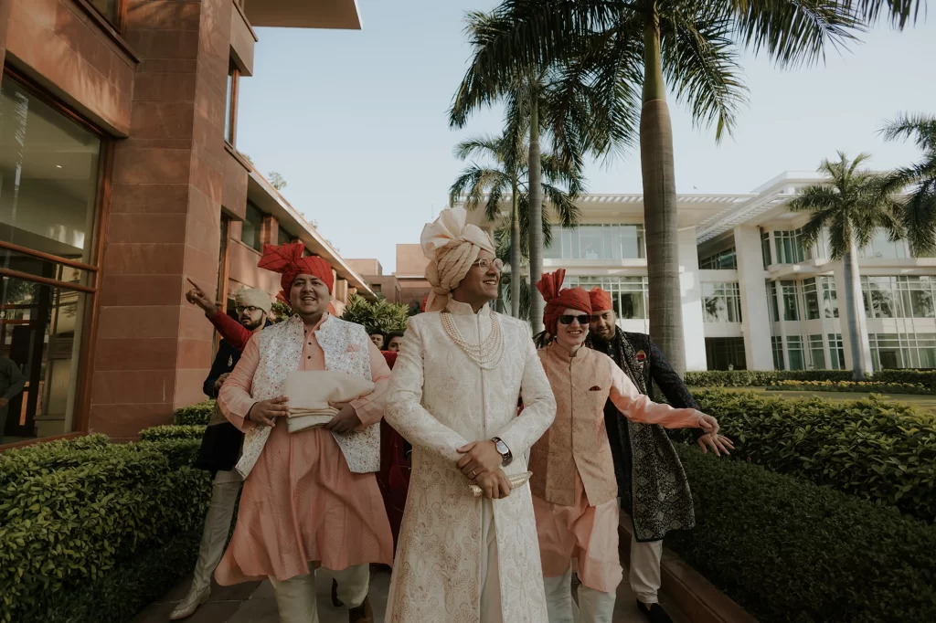  A groom elegantly walks towards the wedding venue, exuding confidence and anticipation as he approaches the auspicious celebration.  