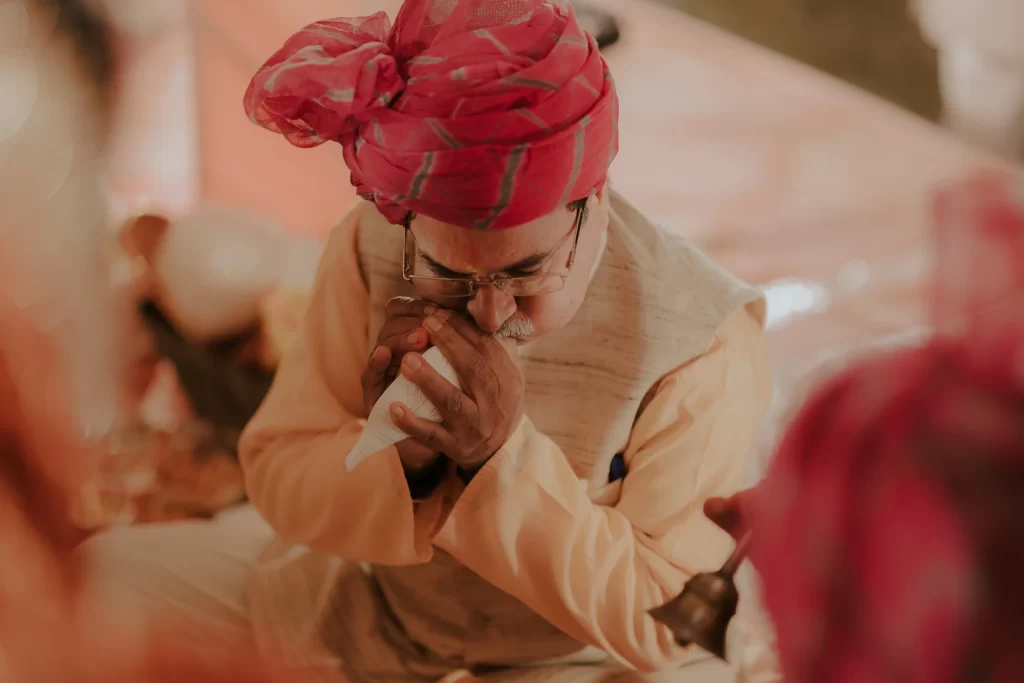  In a traditional setting, the pandit ji plays the shank (conch shell), symbolizing auspicious beginnings and spiritual significance in ceremonies.  