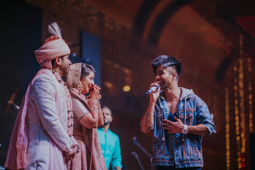 Singer Harrdy Sandhu performs at a wedding, captivating the bride and groom with his soulful melodies and captivating voice.