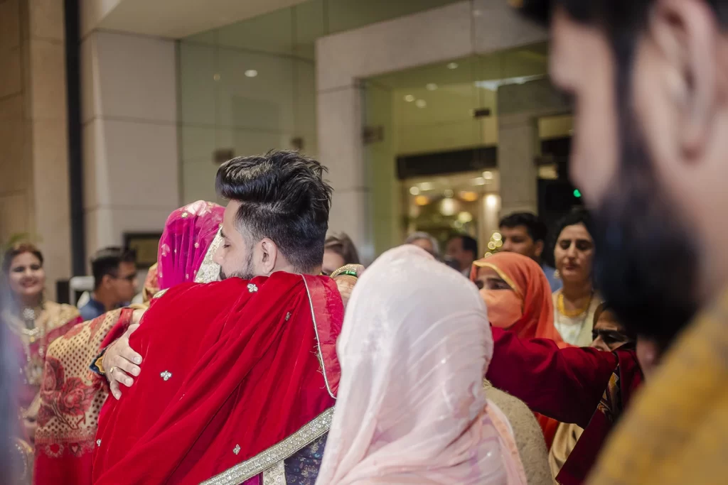 Emotional moment as the bride and her brother share a tender hug during her bidai, displaying love and poignant farewell.