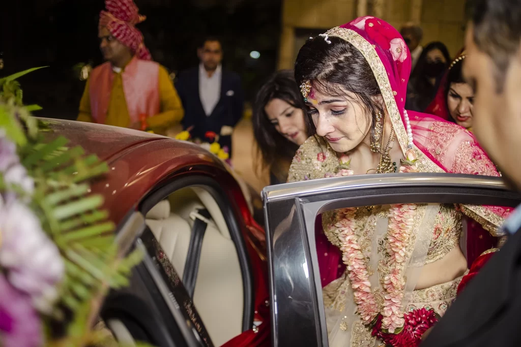 The bride sits in the car during her bidai, shedding tears in an emotional moment as she leaves for her new journey.