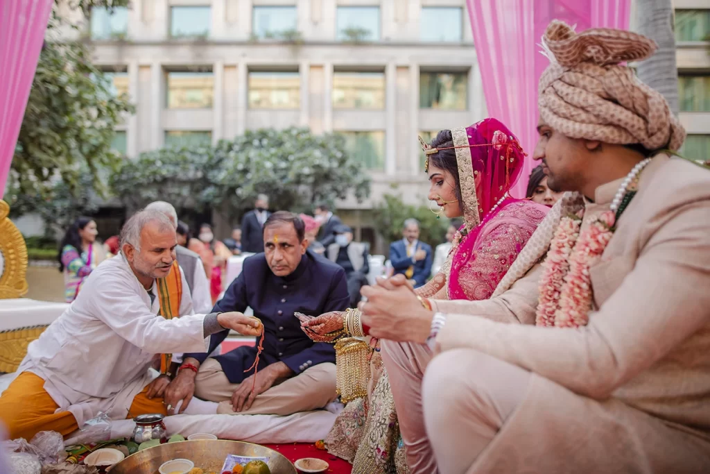 Bride and groom partake in sacred ceremonies, symbolizing their union and commitment in a beautiful and traditional wedding setting.