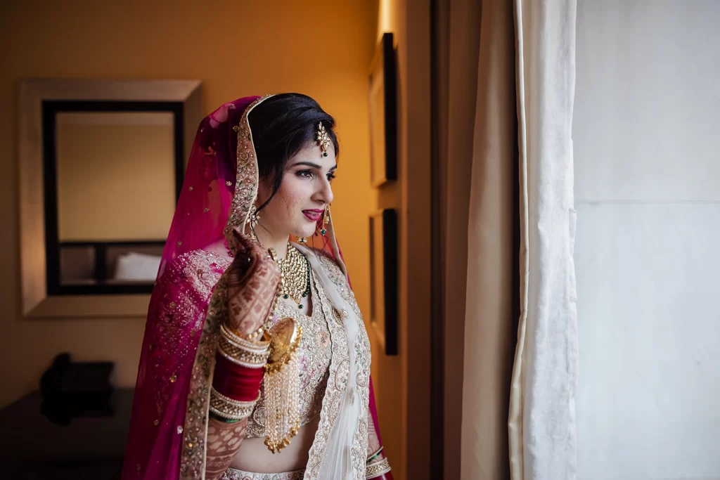 Stunning Indian bride poses elegantly for a photo shoot post-preparing for her luxurious destination wedding at The Grand, Delhi.