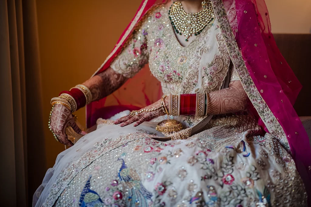 Indian bride radiates beauty and charm during a photo session showcasing her exquisite destination wedding attire at The Grand in Delhi.