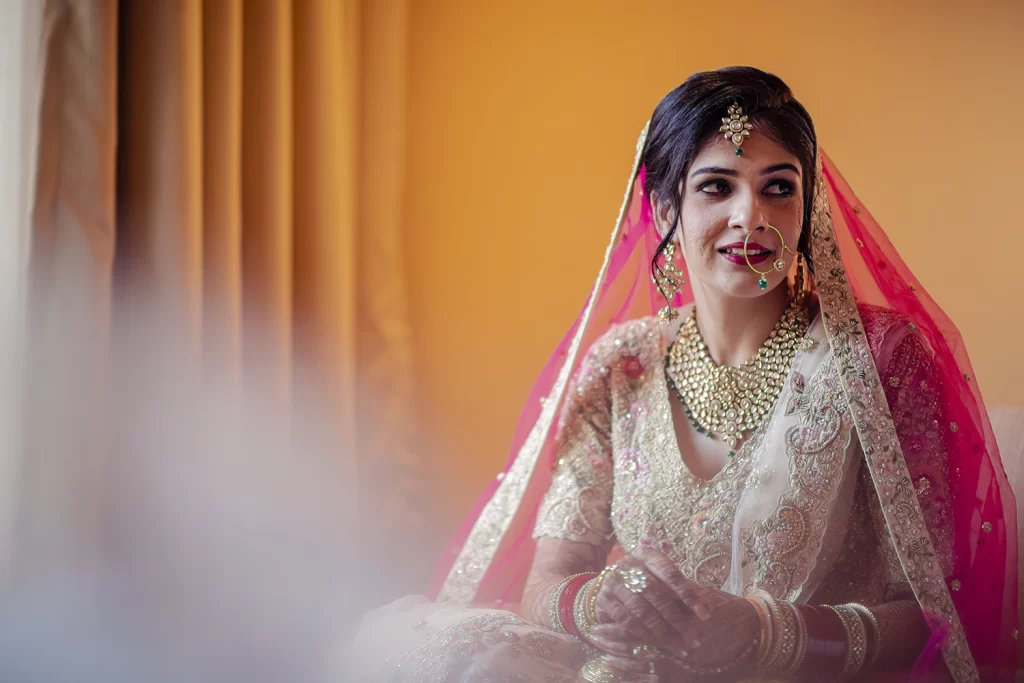 A bride, in full wedding attire, sits elegantly for her portrait after getting ready for the ceremony.