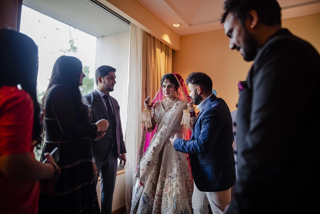 Joyous Indian bride surrounded by loved ones, sharing laughter and creating cherished moments pre-wedding.