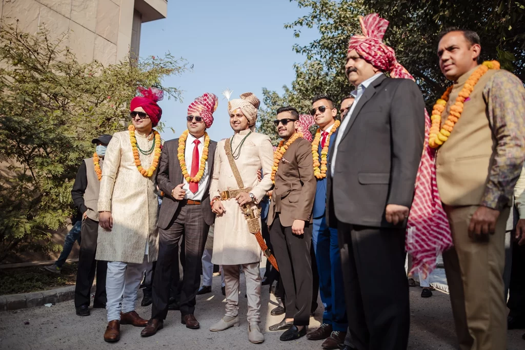 Groom in traditional attire prepares to enter the wedding venue, exuding anticipation and readiness for the ceremonies.