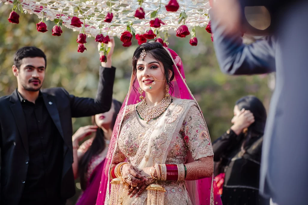 Bride graced by a phoolon ki chadar held by her brothers, makes her way to the mandap in a touching ceremony.