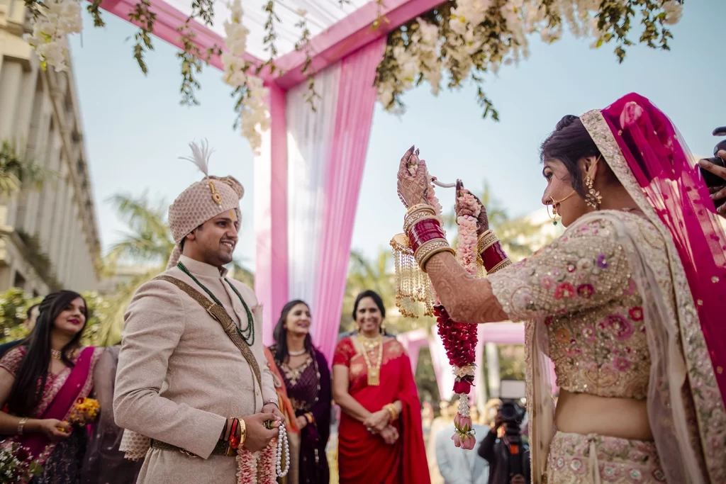 Exquisite varmala ceremony at The Grand, Delhi, showcasing the couple exchanging garlands amidst vibrant decor and joyous celebrations of their destination wedding.