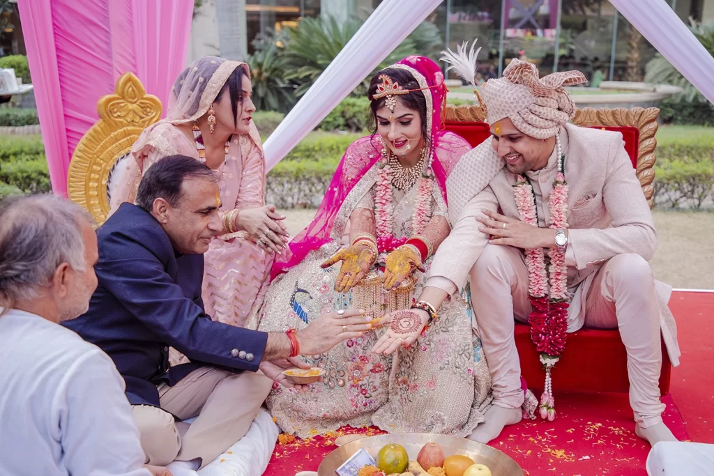 Bride and groom engage in traditional marriage customs, marking the beginning of their shared journey in a joyous ceremony.