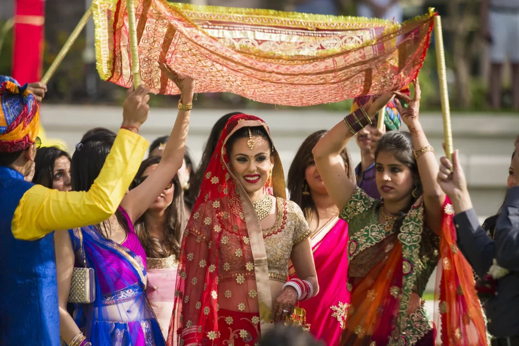 The bride, in traditional Indian bridal attire, being escorted by family members, creating a heartwarming sight during her entry into the wedding ceremony.