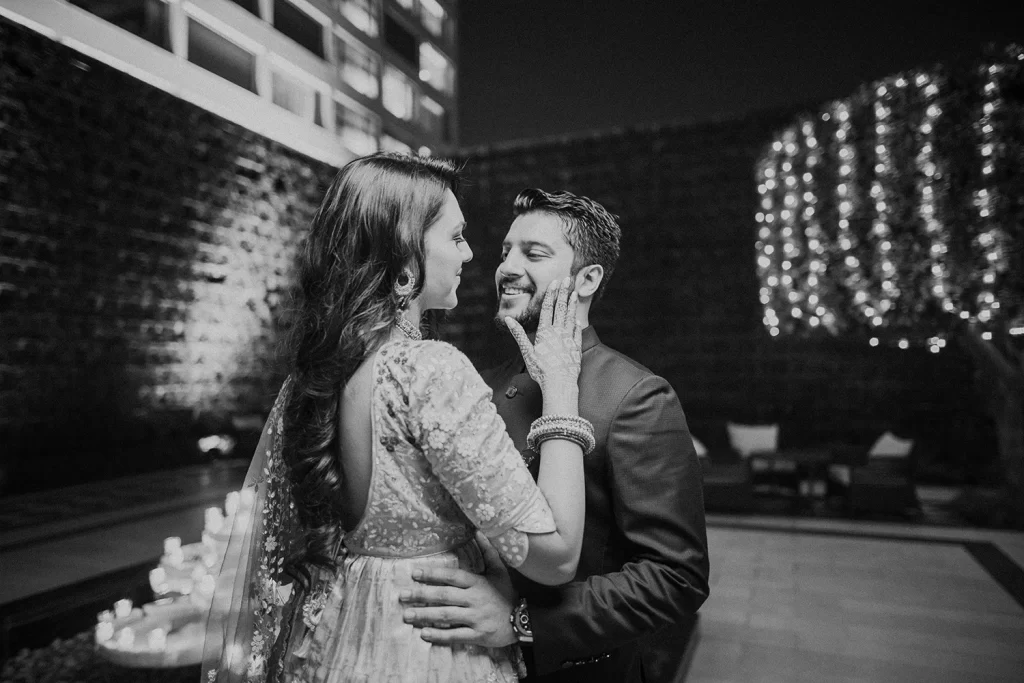 Couple sharing a tender moment in the elegant lobby of The Oberoi, Delhi, with a grand chandelier in the background.