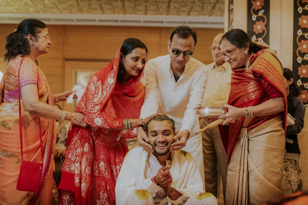 Groom's haldi ceremony: surrounded by family and friends, the groom beams with joy as turmeric paste is applied traditionally.