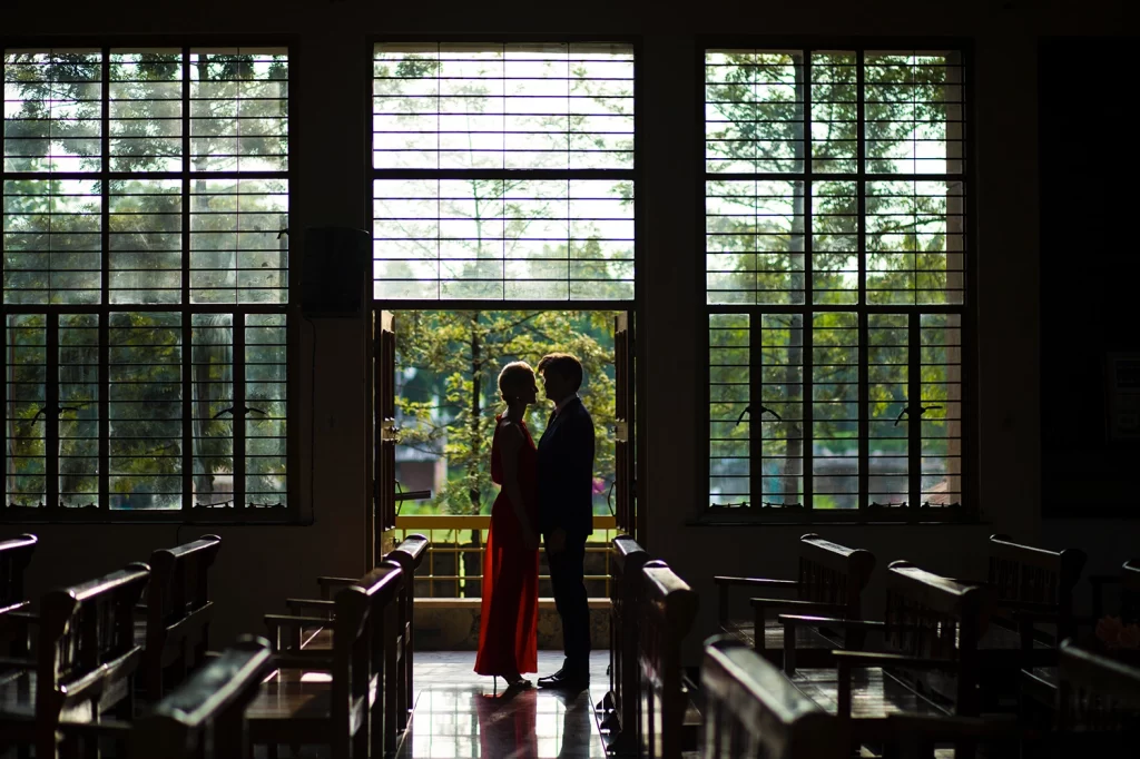 A romantic couple's photoshoot capturing the bride and groom standing outside the church, radiating joy and love against the backdrop of the church's stunning architecture