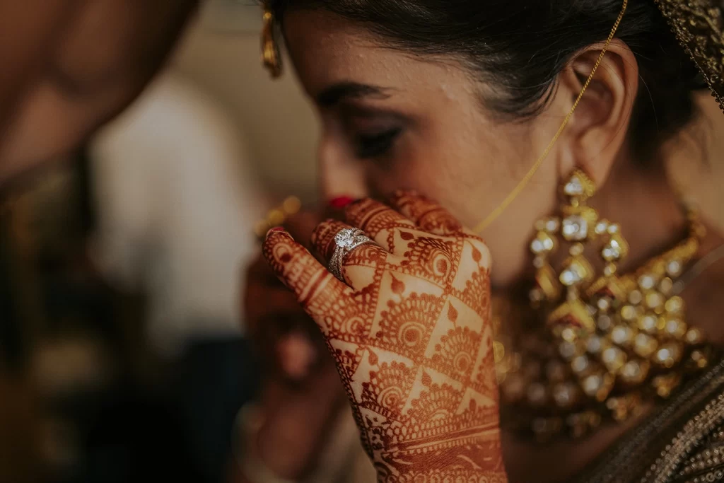 Radiant bride getting ready, gracefully adorning a nose pin, her anticipation and happiness shining through as she prepares.