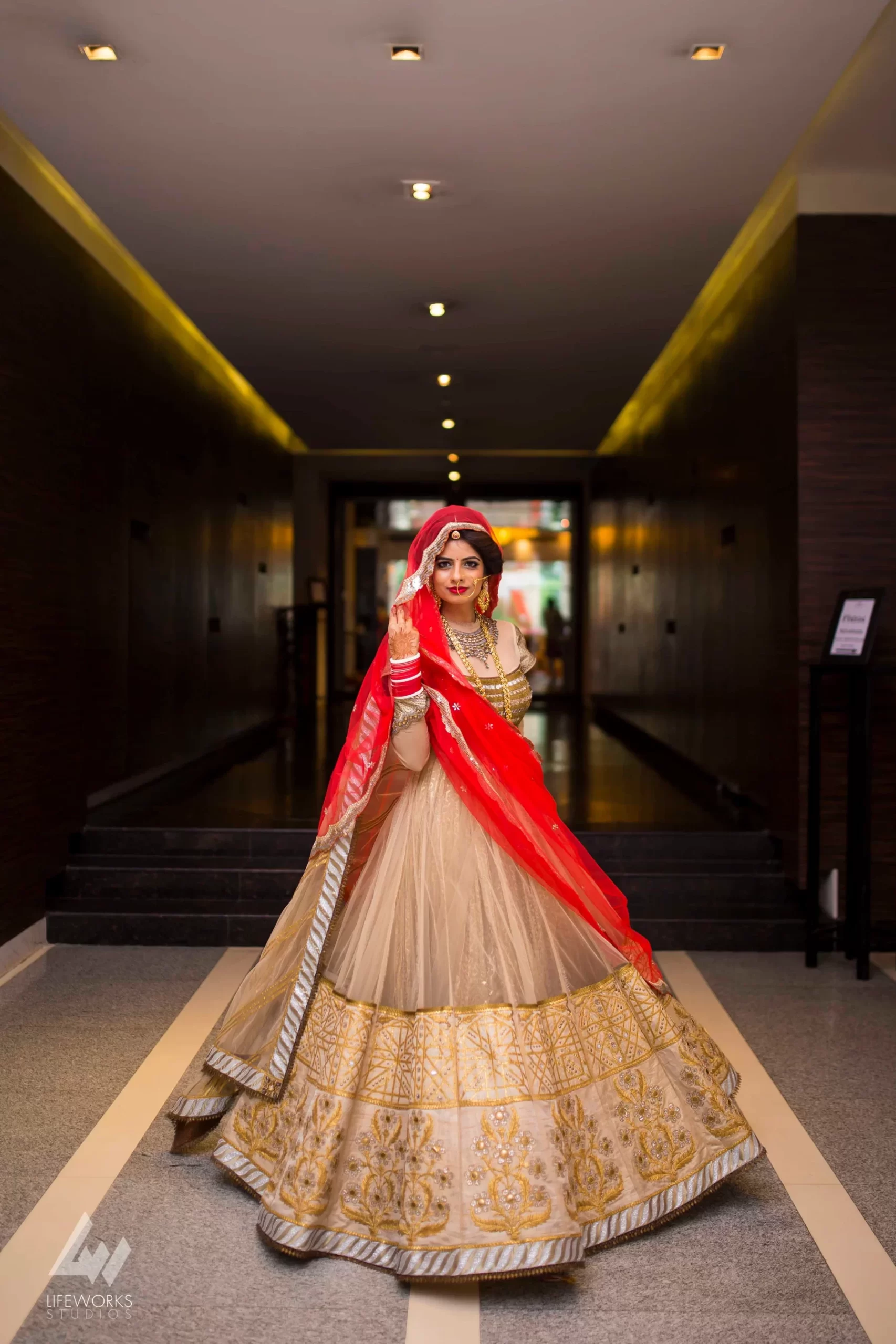 An Indian bride adorned in traditional attire, exuding elegance and grace on her special day, showcasing the cultural richness and beauty of her wedding ensemble.