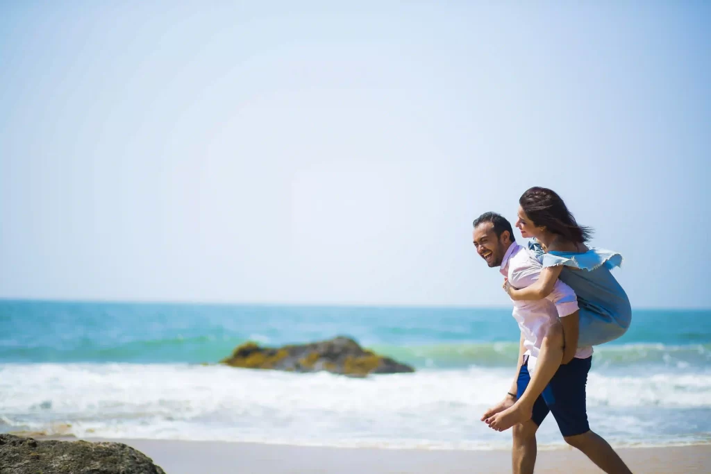 Couple embracing on a scenic beach during their pre-wedding shoot in Goa.
