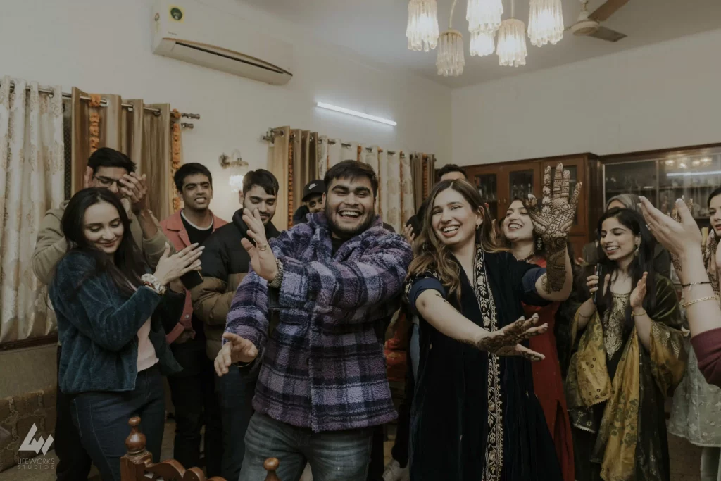 Bride joyfully dances with friends and relatives at her mehndi ceremony, energized by traditional Mehndi songs for wedding.