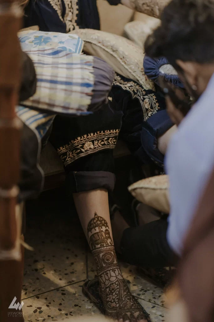 A close-up of mehndi patterns on feet, featuring elaborate designs that complement the bride's outfit.