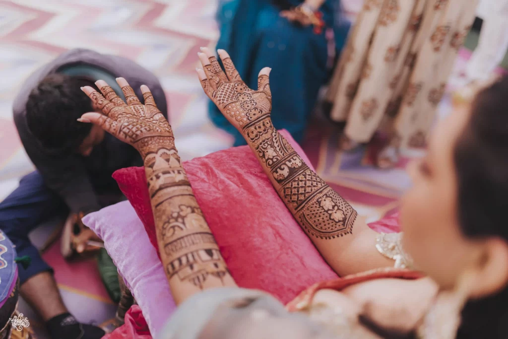 Close-up of detailed mehndi designs featuring traditional motifs on a bride's palm.