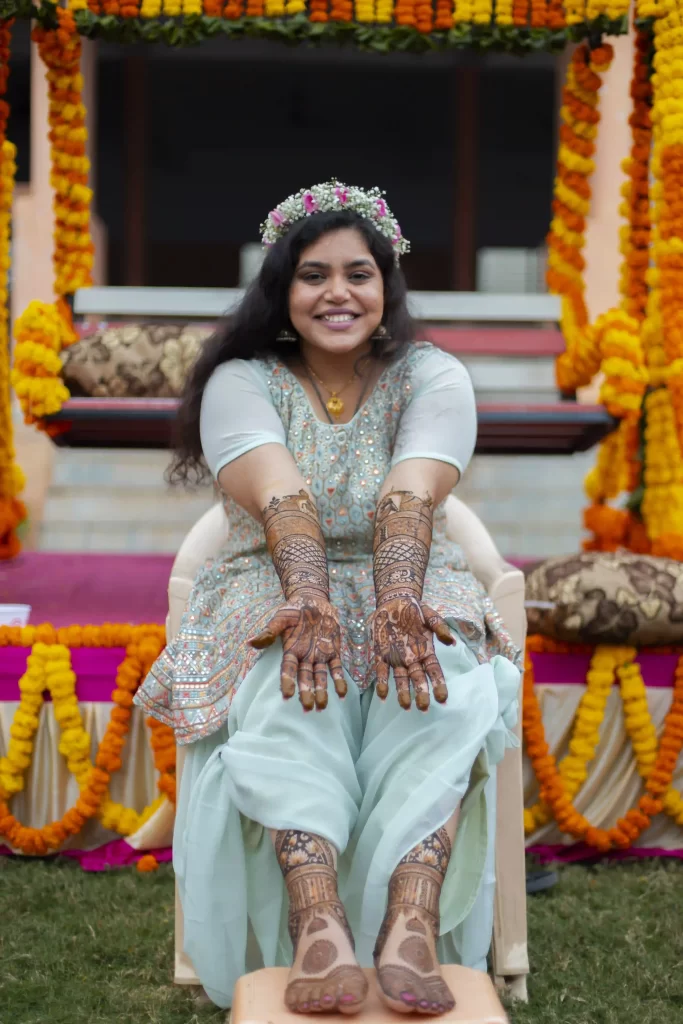 The bride proudly displays her elaborate mehndi design, showcasing intricate patterns and cultural significance.