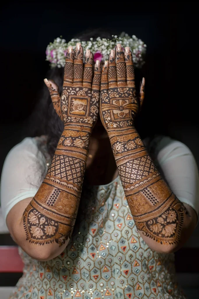 The bride proudly displays her elaborate mehndi design, showcasing intricate patterns and cultural significance.