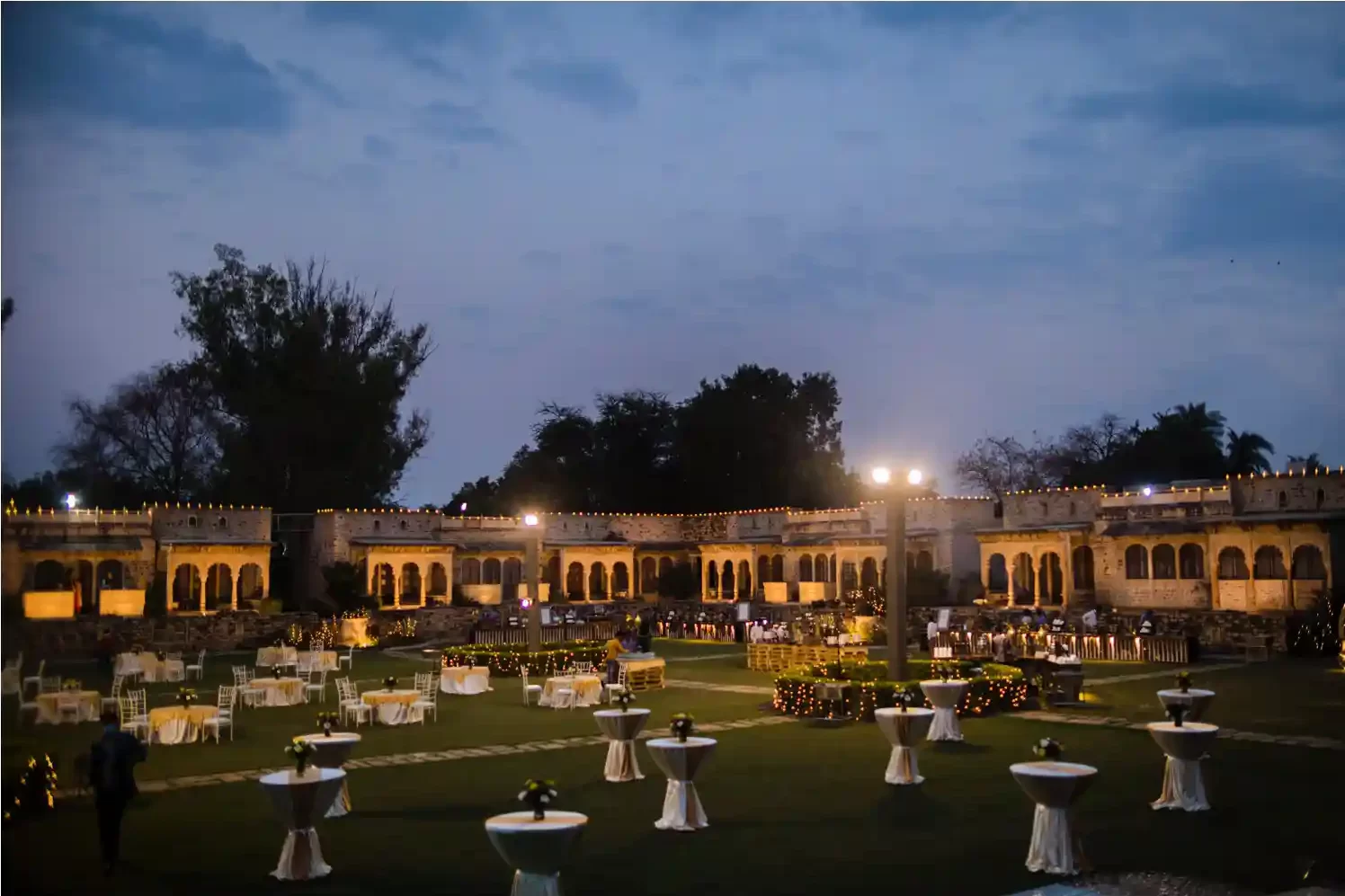 Wide-angle shot showcasing the breathtaking architecture of Neemrana Fort as a backdrop for a destination wedding celebration.