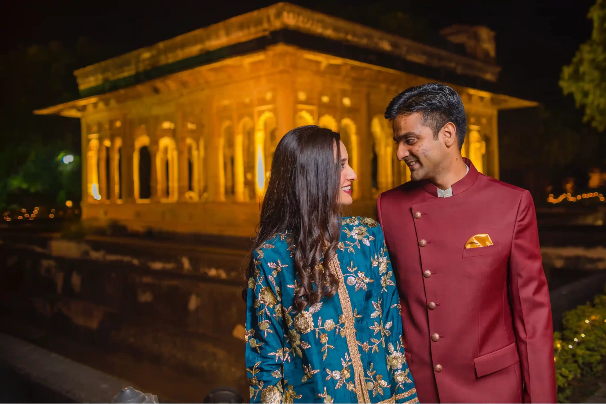 Intimate moment between the couple at Neemrana Fort, framed by the beautiful backdrop of ancient walls and lush greenery.