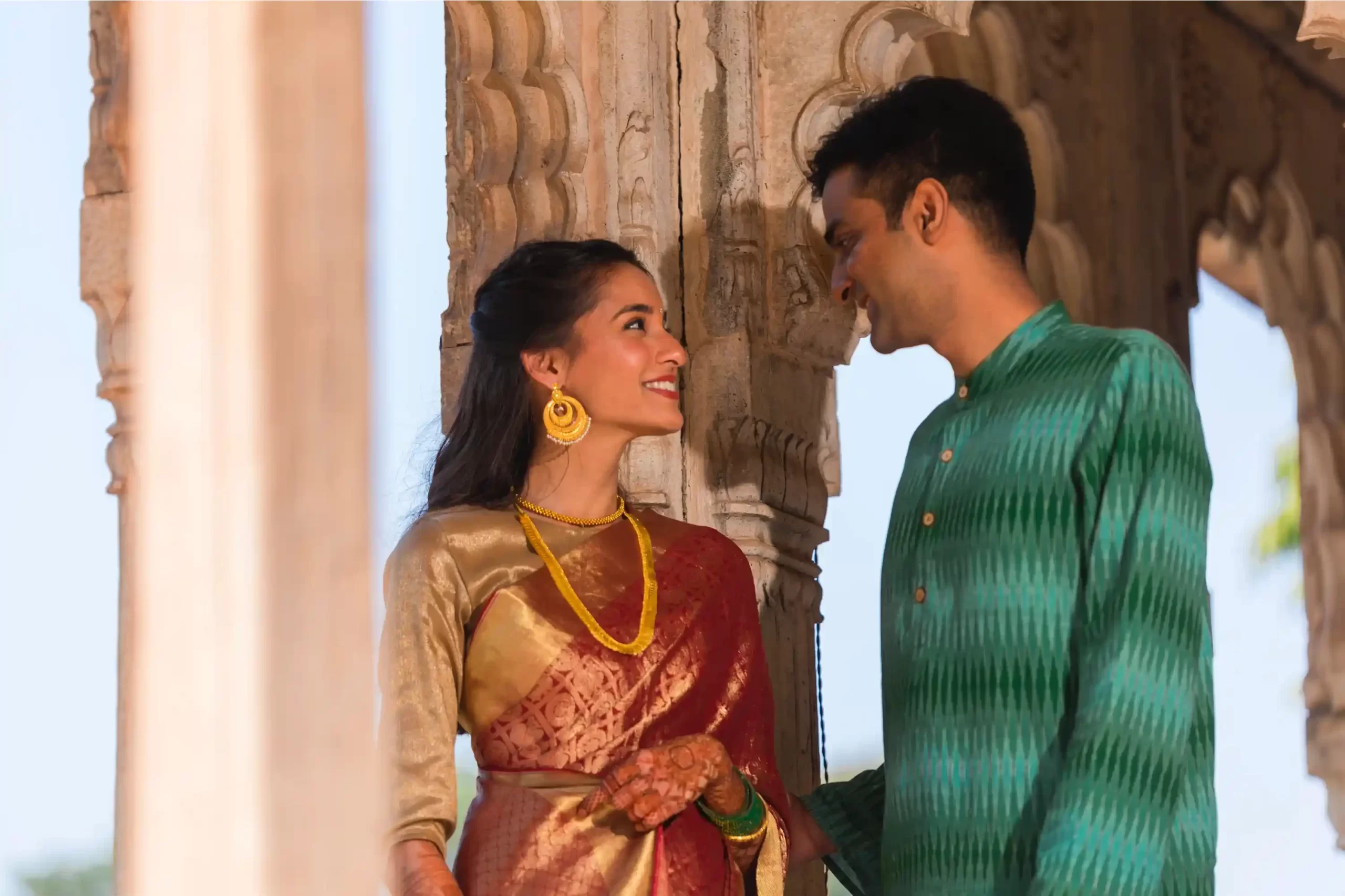 Intimate moment between the couple at Neemrana Fort, framed by the beautiful backdrop of ancient walls and lush greenery.