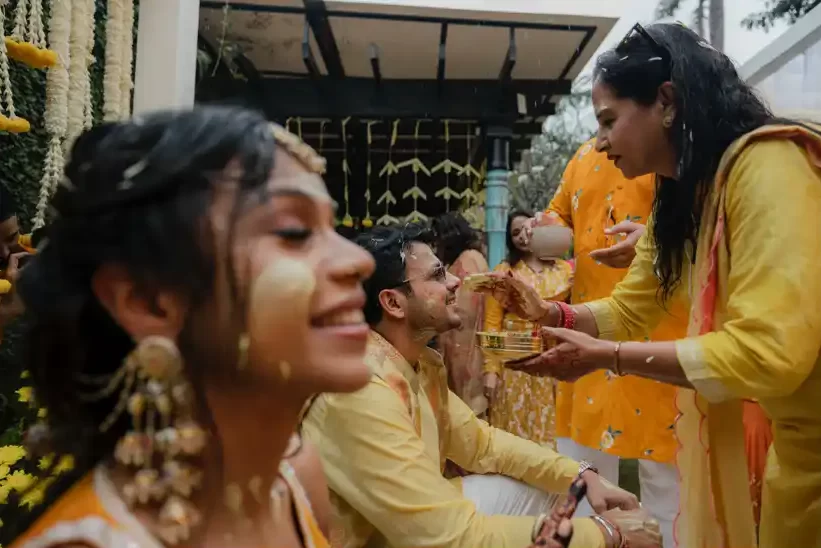 A joyful Hindu wedding in Dubai features the vibrant haldi ceremony, where family members apply turmeric paste to the bride and groom.